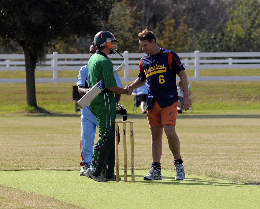 Old Cranleighan Cricket Club bowler Ed Copleston, left, congratulates Richard Barker of the Cayman Islands.