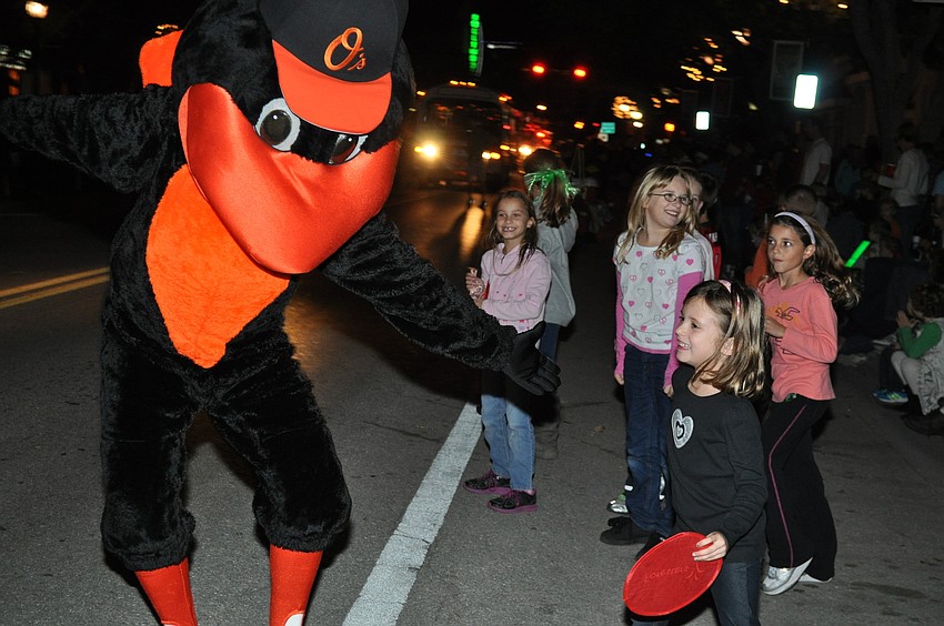 The Baltimore Orioleâ€™s Mascot The Oriole Bird hands out candy to Sarasota children