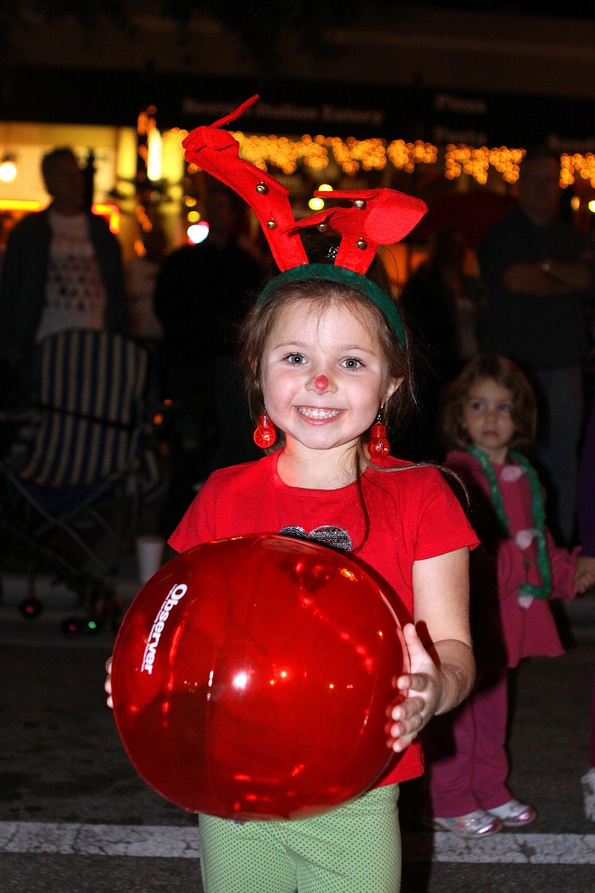 Mackenzie Heise, 5, was dressed in red and green with reindeer antlers and a red nose as she watched the parade Saturday night.