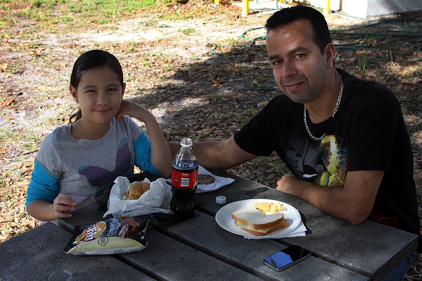 Audrey Arauz, 8, enjoys lunch with her dad, Alvaro, Saturday, Dec. 3, during Fruitville Elementary's junior archaeology day.