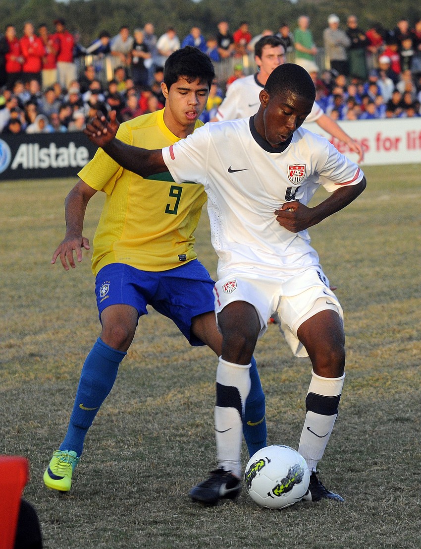Defender Shaquell Moore tries to maneuver the ball past a Brazilian opponent.