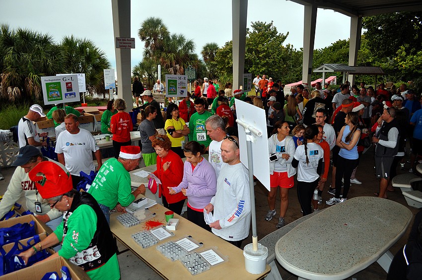 People mingled and waited in lines to get their numbers, Saturday, Dec. 10, for the 35th annual Sandy Claws run on Siesta Key Beach.