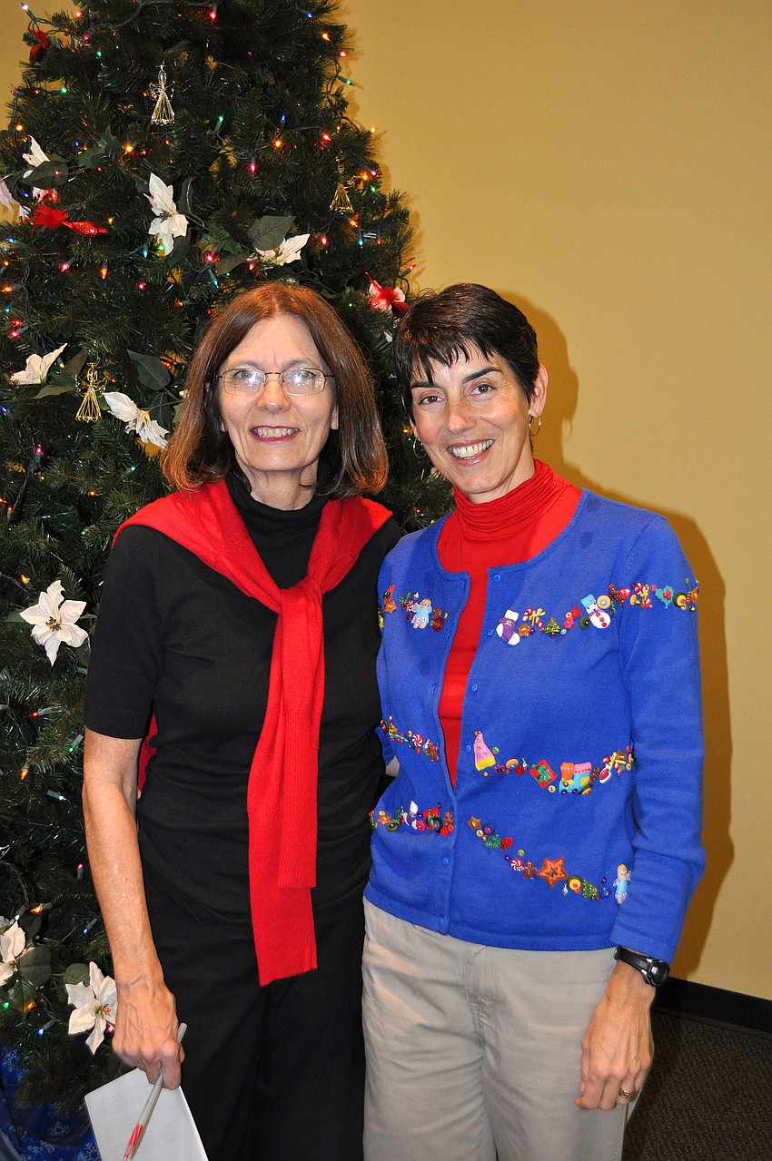 Peg Davant and Betsie Danner pose together by the tree in the Parish Hall.