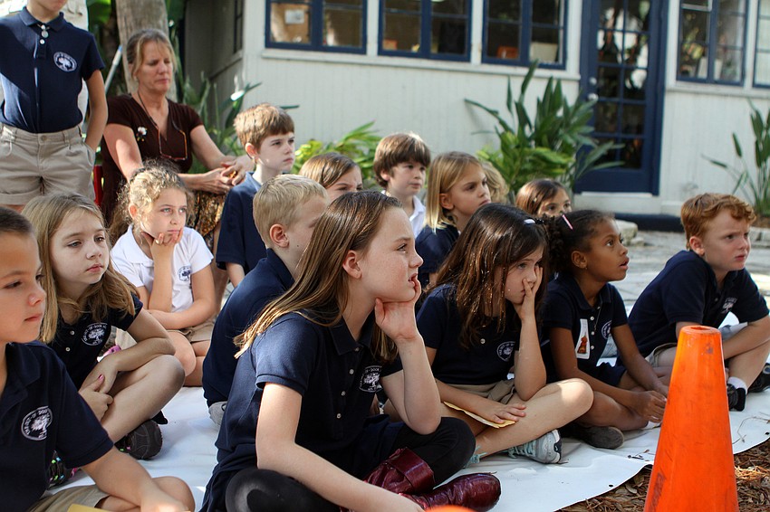 The students listen to Brian Wigelsworth talk about sand sculpting.