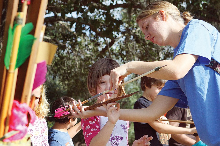Charlotte Jaffe gets some help with the atlatl (spear thrower) from Jessie Ploss in December at New Collegeâ€™s Public Archaeology Lab.