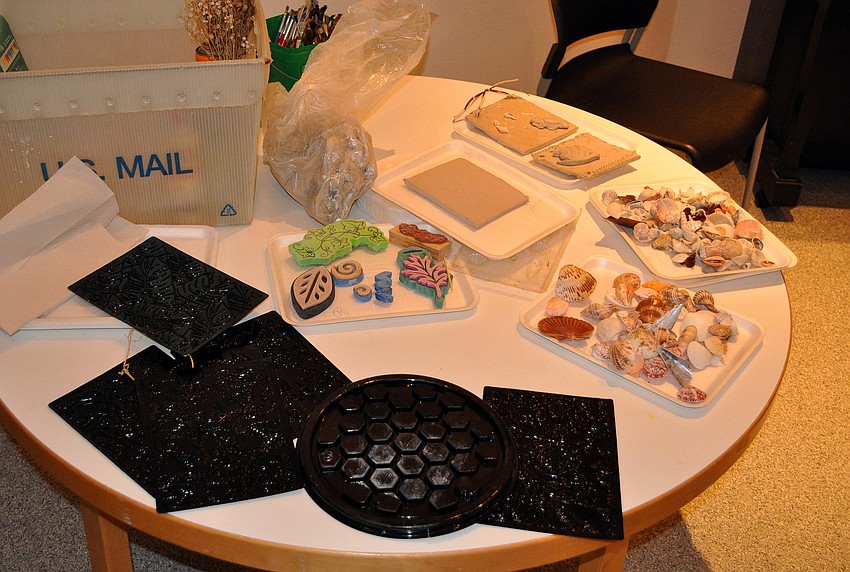 A table was filled with patterned sheets, shells, molds and stamps that were all available for use on the clay plaques.