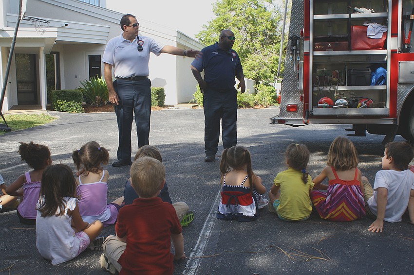 Lieutenant Firefighter Scot Gottschalk and Firefighter Ricky James talk what to do in the event of a fire, and show-off their truck and equipment to 27 eager students at St. Boniface Preschool.