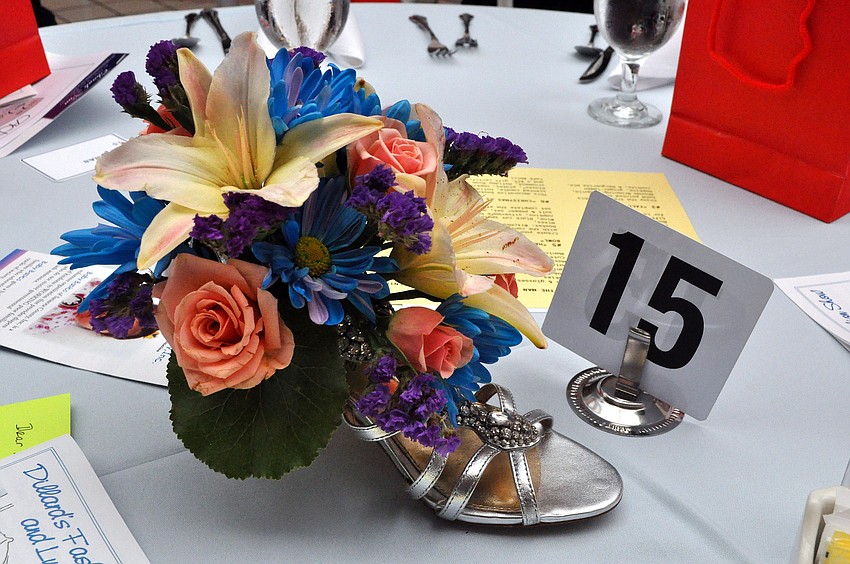 Each table had a shoe with a floral arrangement propped up inside.
