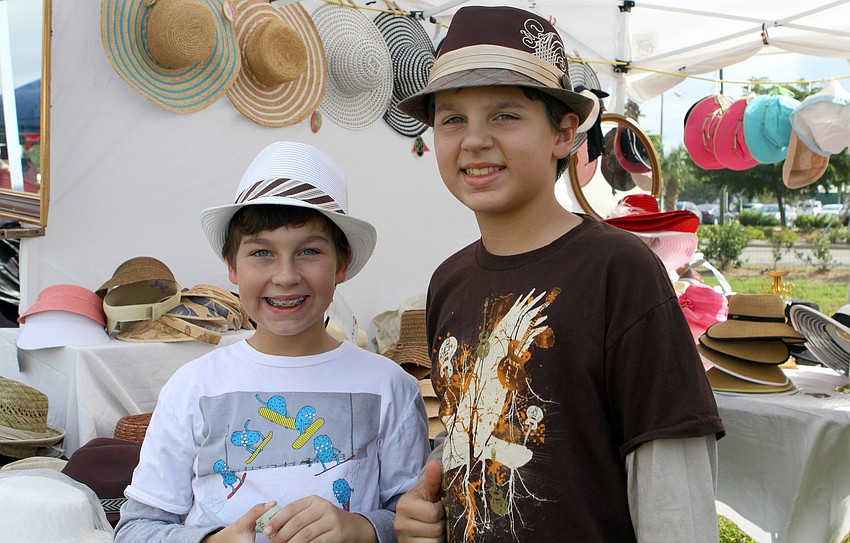 Camiron Myers, 12, and Corbin Gilpin, 11, try on some hats at the Mad Hatter tent.
