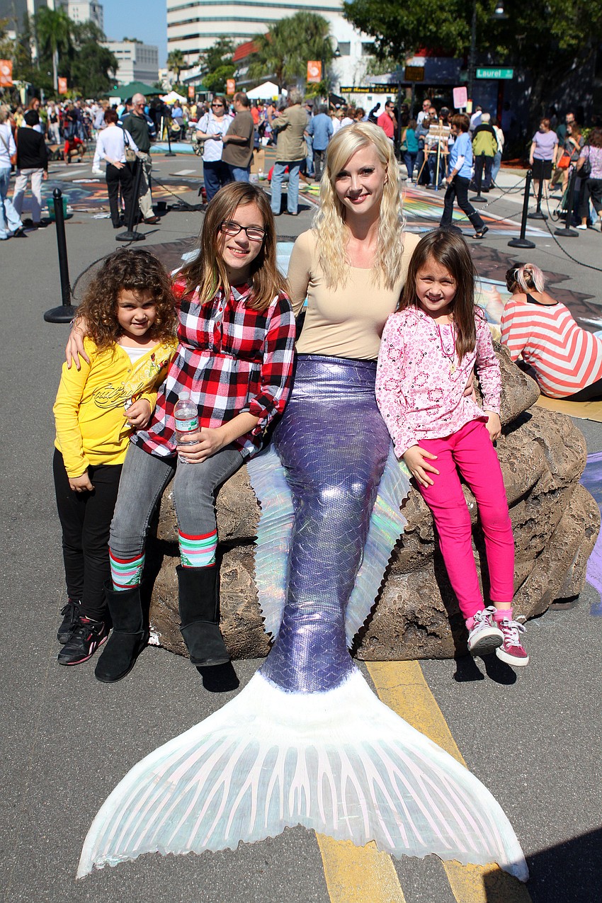 Bella Betancort, 5, Alex Finnerty, 11, and Kayla Chapa, 7, pose with the mermaid, Chelsea Johnson, Saturday, Nov. 5 in Burns Court.