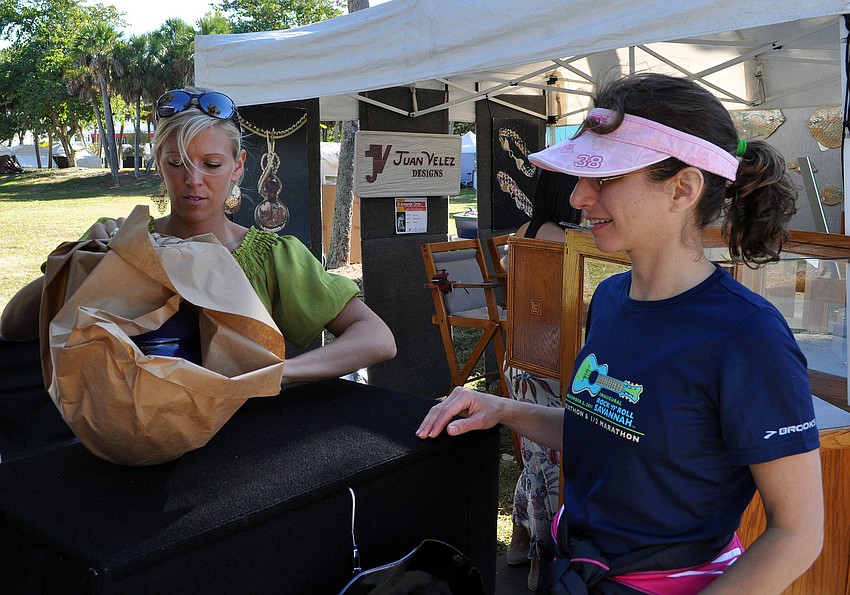 Lani Ragan, right, waits as Jenny Martin wraps up a piece of pottery created by Scott Martin Pottery.