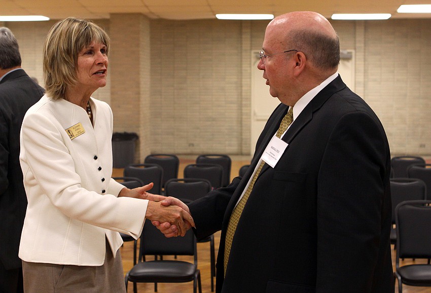 Mayor Suzanne Atwell shakes hands with Randall Reid at the 