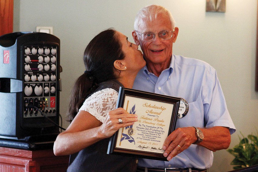 Three-time scholarship recipient Fatima Morais Paul plants a kiss in Scholarship Committee Weldon Frostâ€™s cheek during the Kiwanis Club of Longboat Key Foundation scholarship ceremony in August.