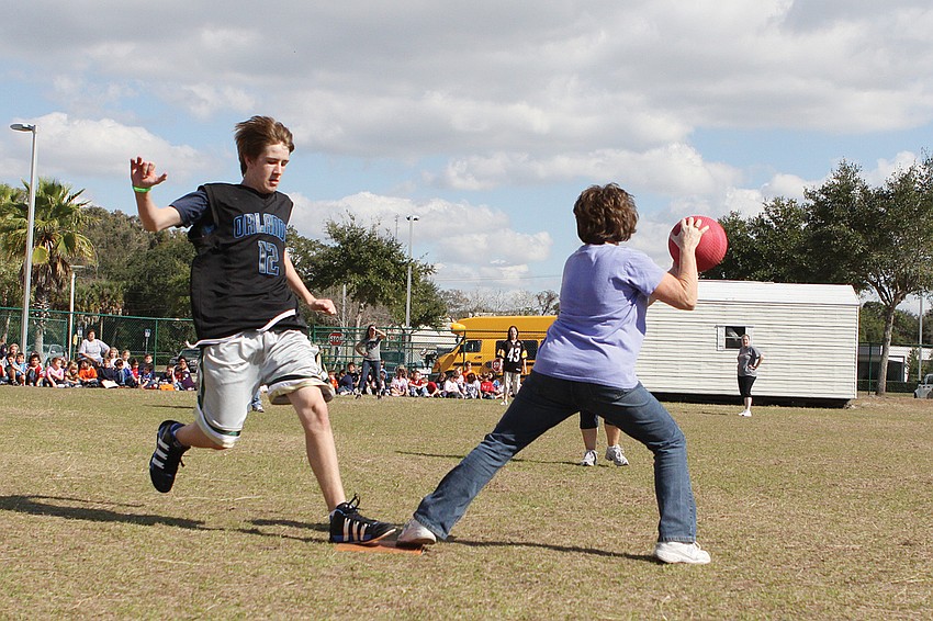 St. Martha Catholic School first-grade assistant Debbie Lamielle, right, made the play at first base to get out eighth-grader John Dowling in a January kickball game between eighth-graders and their teachers.