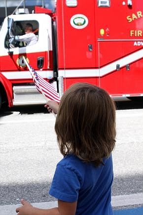 Brittin Sullivan, 4, waves his flag at one of the fire trucks that went by Sunday, Sept. 11, during the Remembrance March.