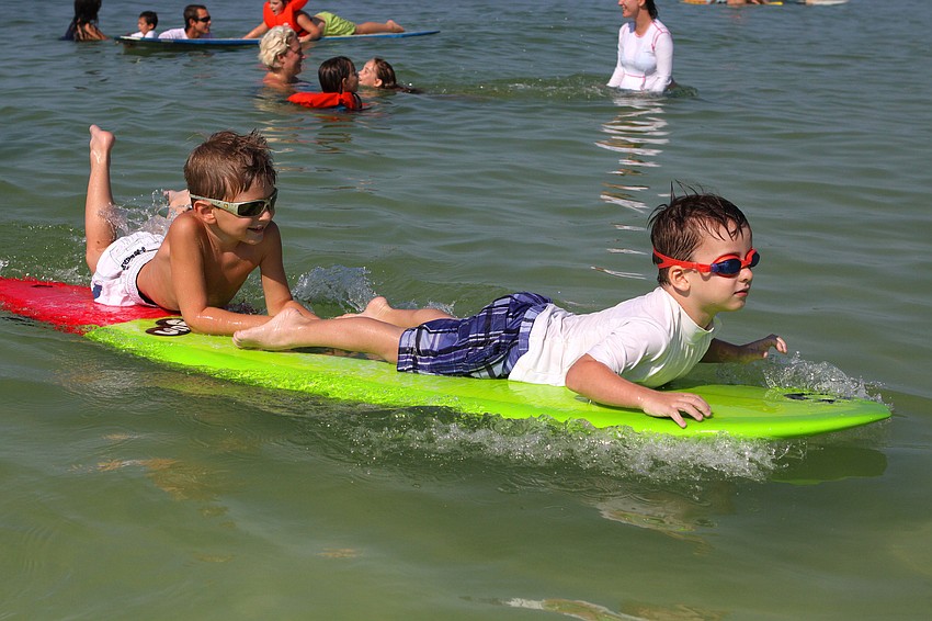 Caleb Holland, 5, and Evan Crowe, 4, take a ride together Saturday, Sept. 17, at the Siesta Key Public Beach.