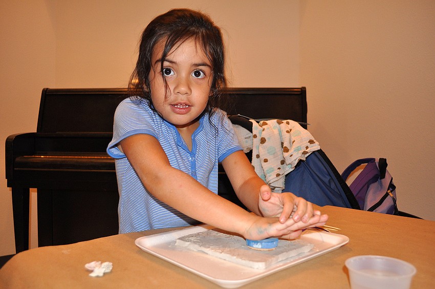 Juliana Boatwright, 4, uses a stamp on her clay slab.