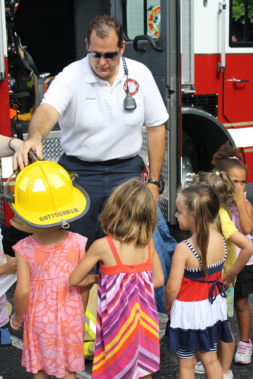 Fire Lieutenant Scot Gottschalk shows the children of St. Boniface Preschool what a fireman wears when he puts out a fire.