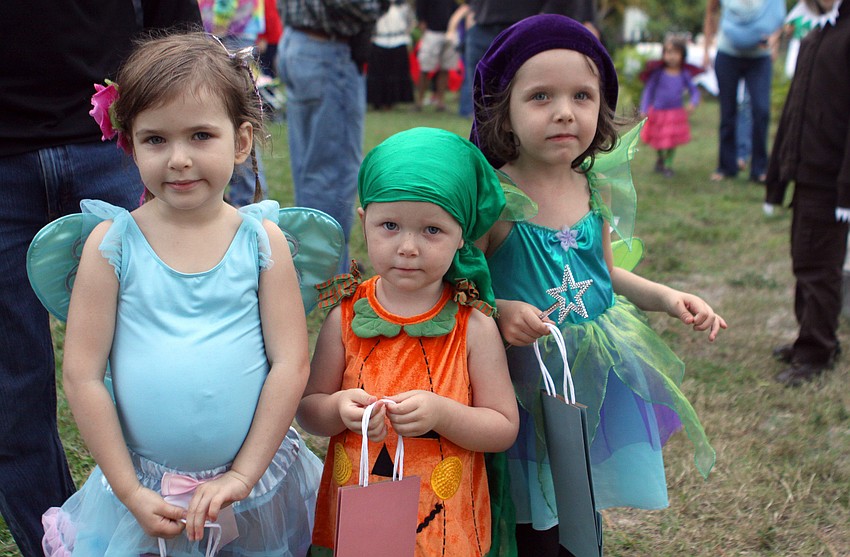 Mia Koob, 4, Cami Todd, 2, and Kendall Todd, 4, pose together, Sunday, Oct. 30, at the Halloween Fest and Lantern Walk at Pine Shores Presbyterian.