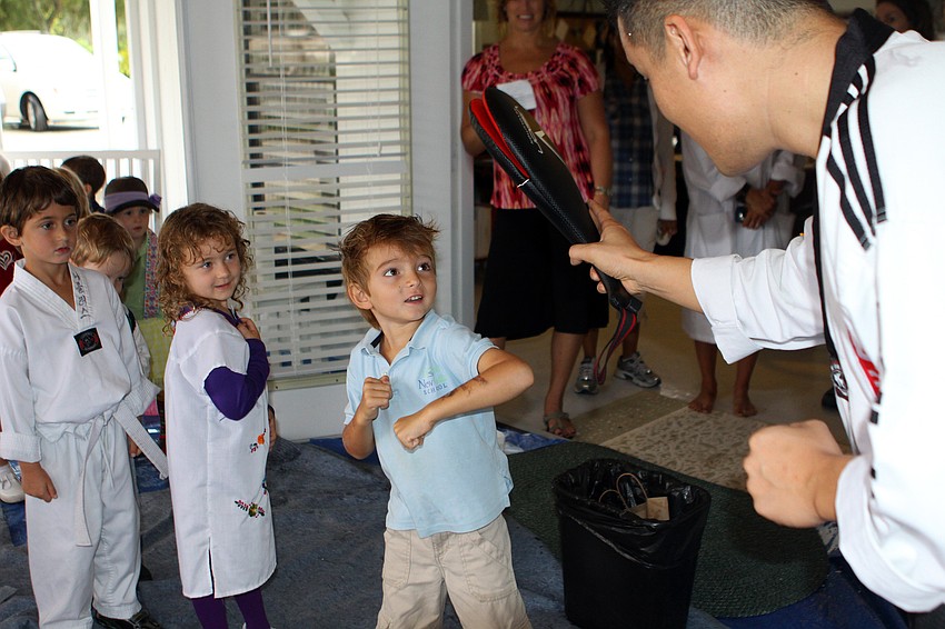 Dylan Foley gets ready to punch the punching pad held by Master Hwang.
