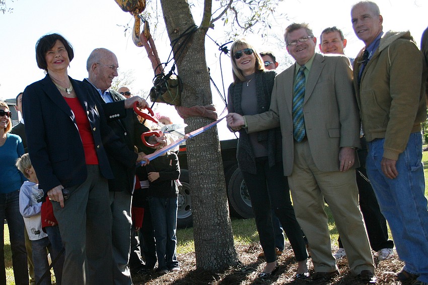 Commissioners Donna Hayes, Larry Bustle and Carol Whitmore, former commissioner Jonathan Bruce, and Commissioner John Chappie cut the ribbon on a tree dedicated to Tom Bennett's memory.
