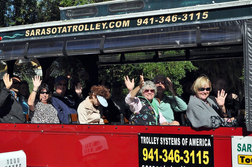 People wave from the trolley.