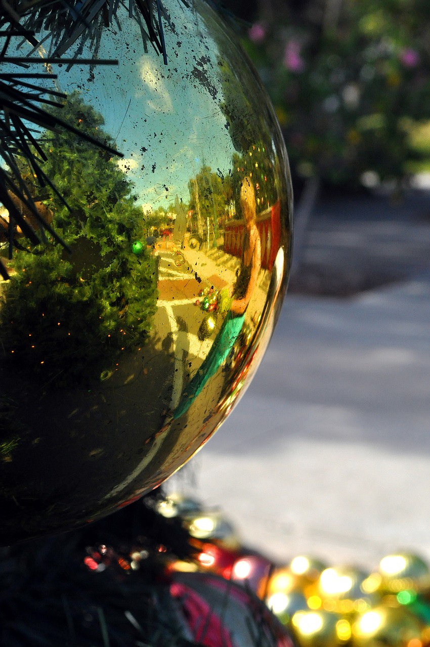 Pamela Scollay and part of St. Armands Circle is reflected in a gold ornament on the Christmas tree.