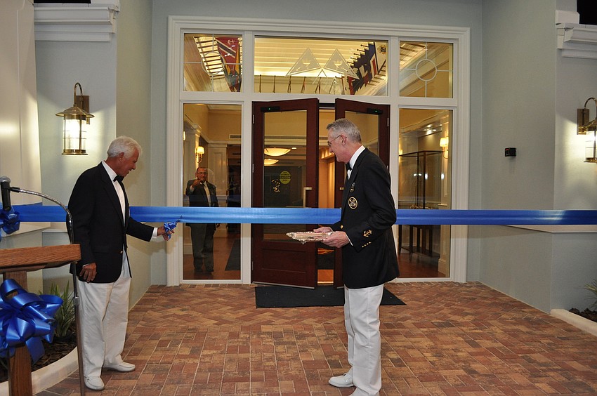 Commodore Bob Baime cuts the ribbon as a ceremonial cannon is fired, the lights turn on and the doors flail open.