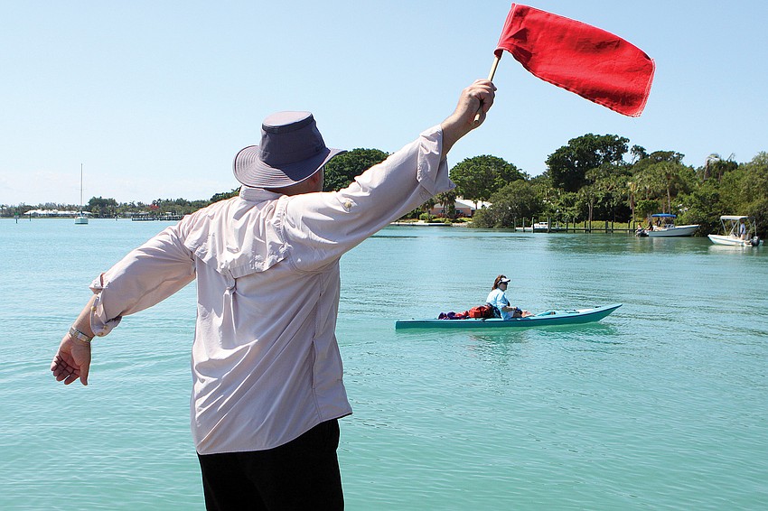 Tom Aposporos waved the red flag as the final competitor, Bonnie Wilson reached the shore during the Longboat Key Challenge in May.