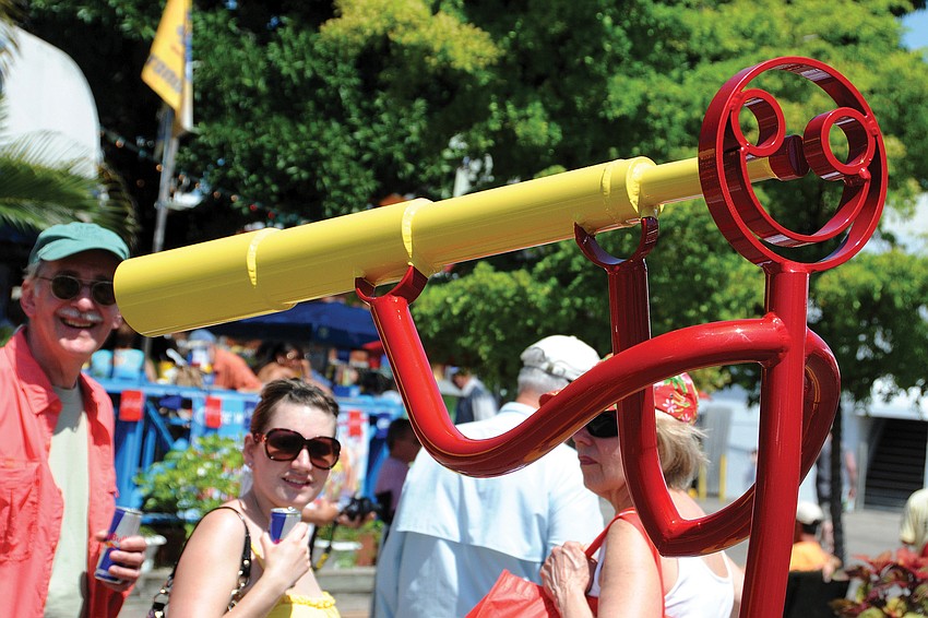 A Tube Dude spies on George and Lisy Palda during the annual Siesta Fiesta in the Village.