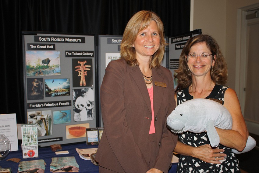 Beth Browning and Martha Wells pose in front of their booth for the South Florida Museum.