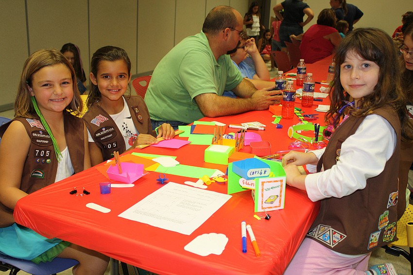 Katie Kelly and Emma Decistro of troop 705 talk to Kathrine Burke of troop 600 while they make crafts.