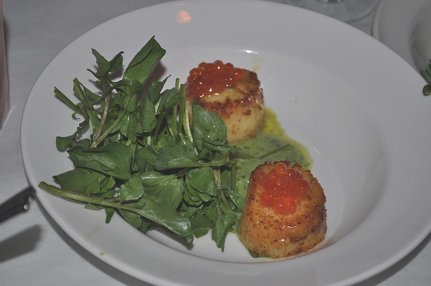 The first course prepared is seared curried diver scallops.