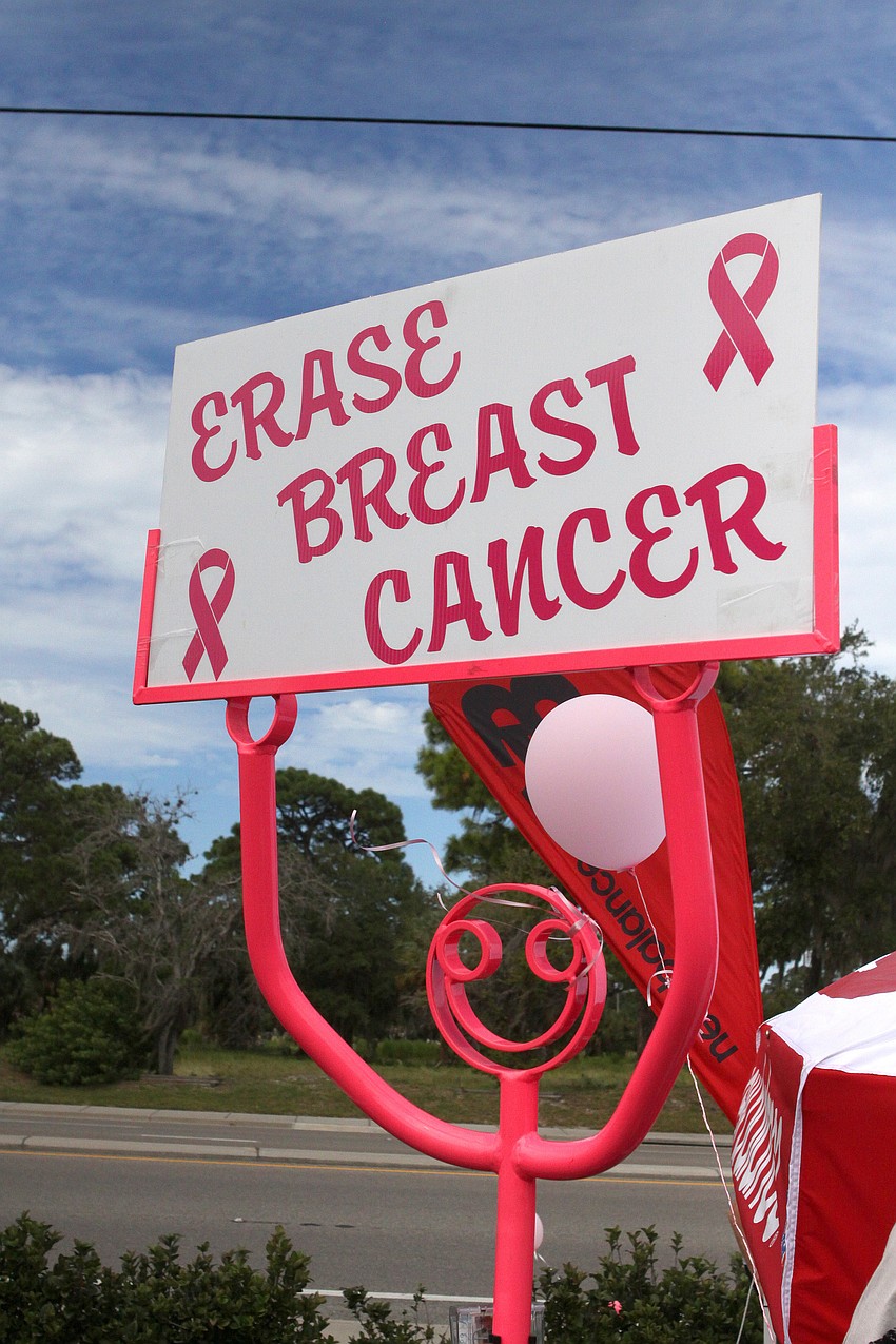 A bright pink tube dude held up a sign saying â€œErase Breast Cancerâ€.