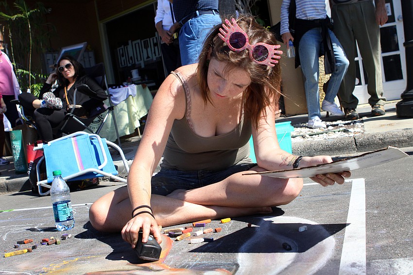 Zoey Carr uses a blackboard eraser to get the effect she wants in her piece.