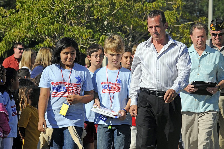 Fifth-graders Britney Guerra and Drew Reaves and U.S. Army veteran David Neff presented the First Responders flag.