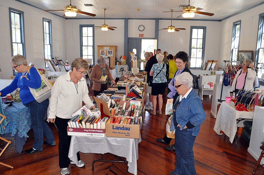 People wander around looking at items for sale inside Crocker memorial church during Pioneer Day.