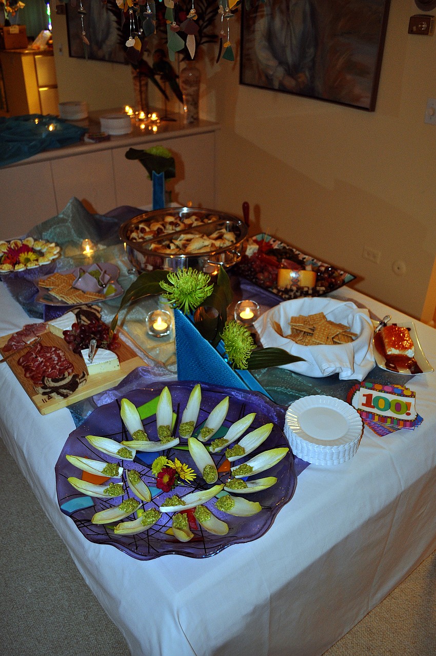 Lois Lesser's dining room table was full of food for people to nosh on while celebrating Ursula Pearson's 100th birthday.