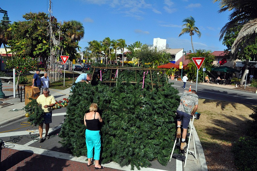 Volunteers worked together to get the branches and ornaments on the St. Armands Christmas tree, Saturday, Nov. 19, out on the circle.