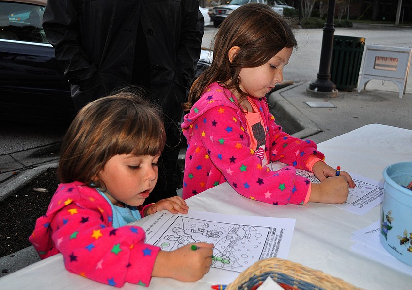 Mallory, 3 Â½, and Ayra, 5 Â½, color pictures out in front of Rosebay Real Estate, Friday, November 9, during Southside Stroll.