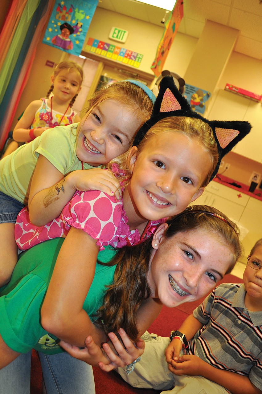 Sydney Prague and Molly Robinson piled on top of their group leader, Katie Wray, at 