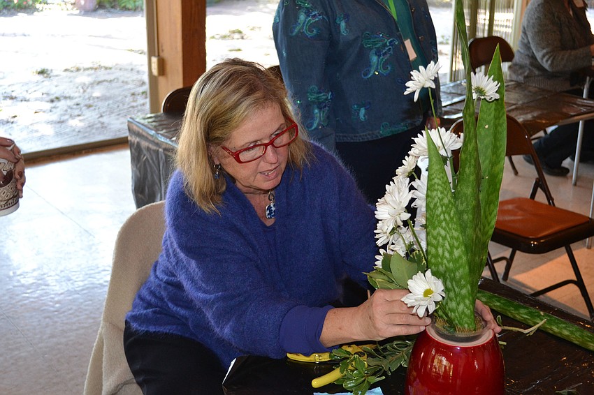 Janice Hamlin looks over a student's arrangement.