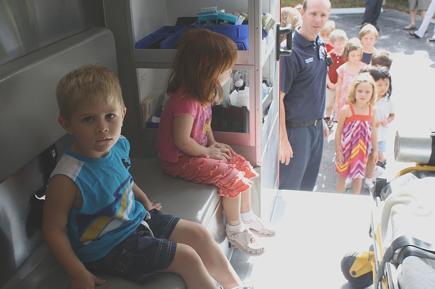 Andre Hersom and Natasha Antoniuk take their turn inside of the ambulance. The rest of the students at St. Boniface Preschool wait their turn in line behind Paul Leverone.