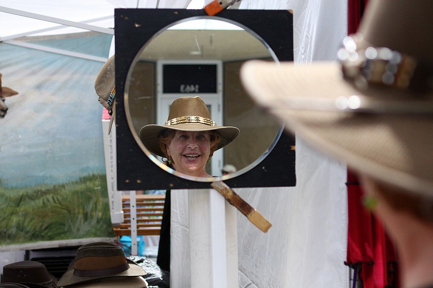 Colleen Nuese-Marine tries on a hat from the Australian Hats tent.