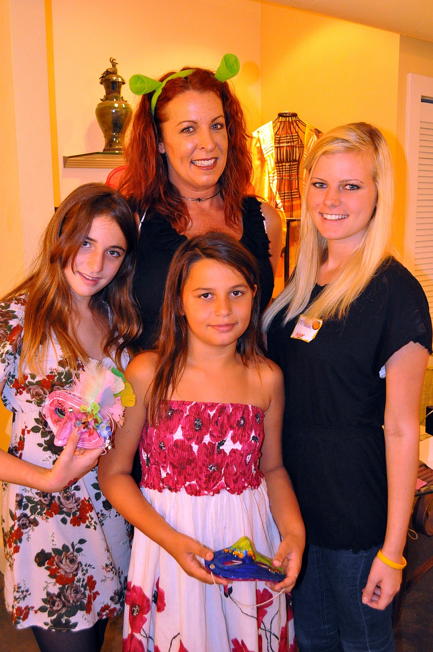 Carey Robards poses with her daughters Grace, 11, Faith, 9, and Miranda, 15, Saturday, Oct. 29, during Family Mask Day at Artists on the Court.