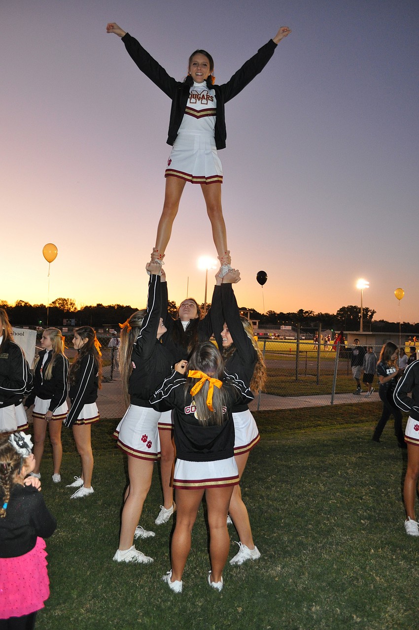 The Cardinal Mooney varsity cheerleaders throw up a stunt