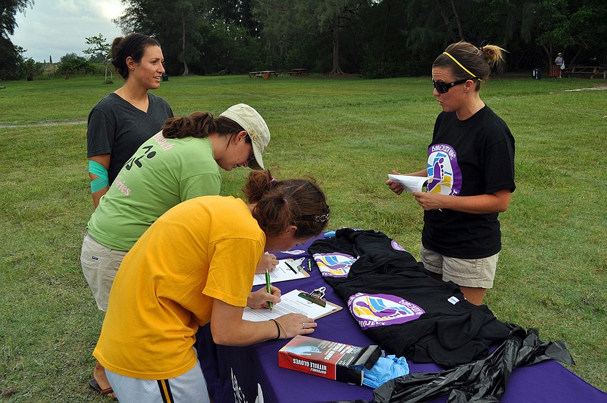 Jana Ritter talks to Gina Santoianni, Dana Henderson and Heather Hooper while they signed up for the Barefoot Wine Beach Cleanup Thursday, Sept. 8, at Ted Sperling Park.