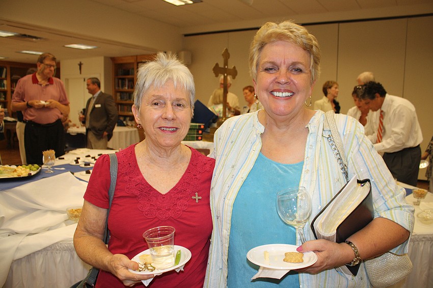 Carolyn Peet and Patricia Brunel make their rounds at the appetizer table. Behind them is a display honoring the King Jamesâ€™ bible, which will celebrate its 400th anniversary on Oct. 9.
