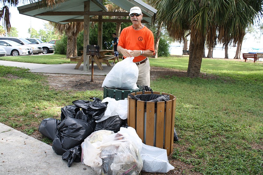 Bruce Weinstein adds one more bag of trash to the pile collected from the bay cleanup.