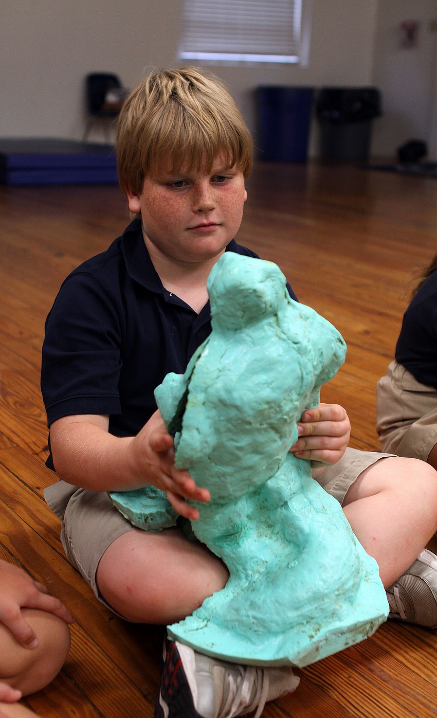 Connor Keane, 9, holds the mold for one of Jack Dowd's sculptures.